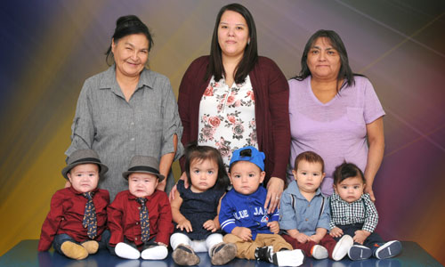 Portrait of preschool children in front of three women